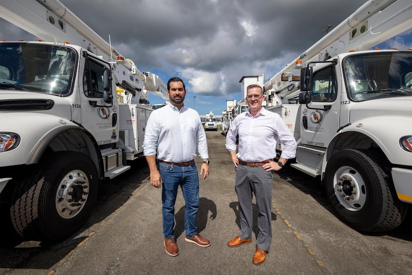 Berríos Portela y Dahlen, jefe de Desarrollo Comercial y vicepresidente de Quanta Services Solutions, respectivamente, junto a parte de la flota de camiones especializados.