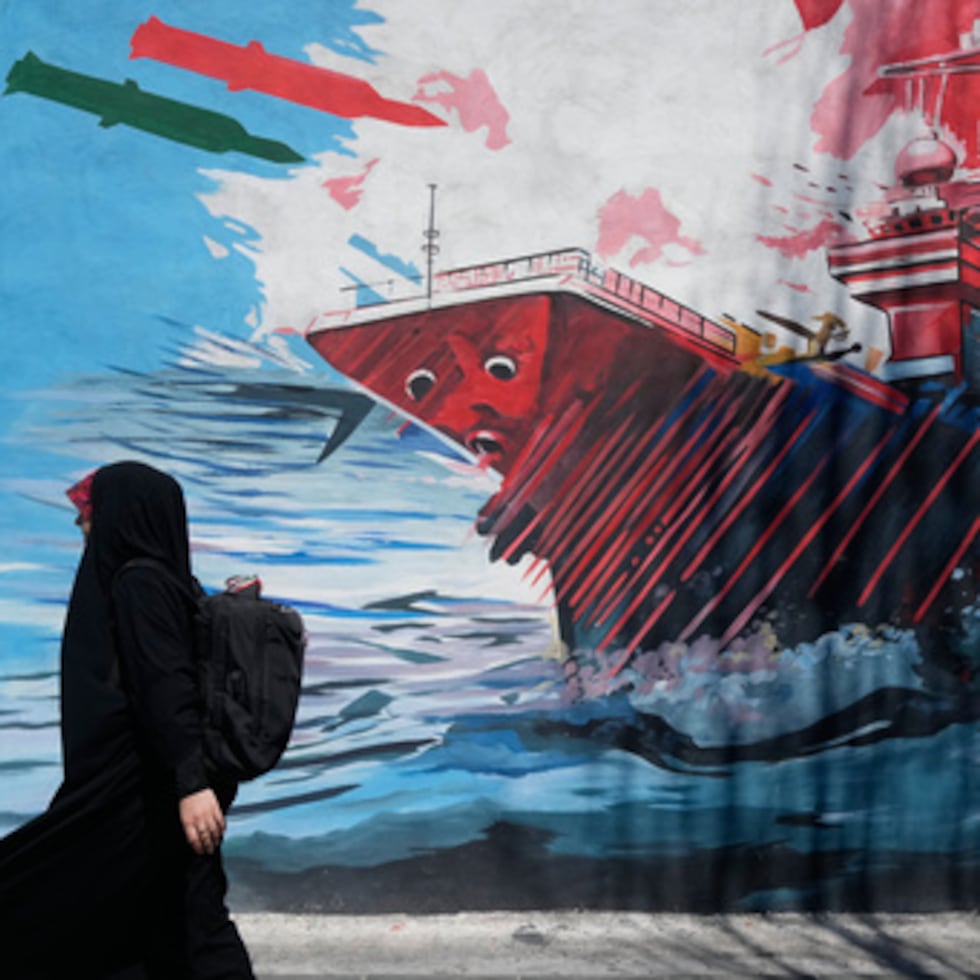 Una mujer pasa junto a un mural que representa un portaaviones estadounidense bajo ataque con misiles en el centro de Teherán, Irán, el lunes 8 de junio de 2026. (Foto AP/Vahid Salemi)