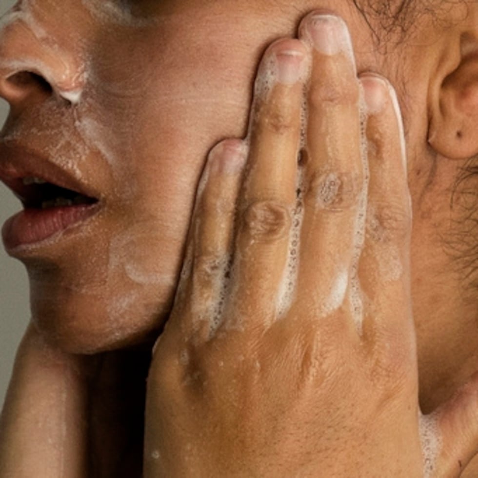 Una mujer se lava el rostro.