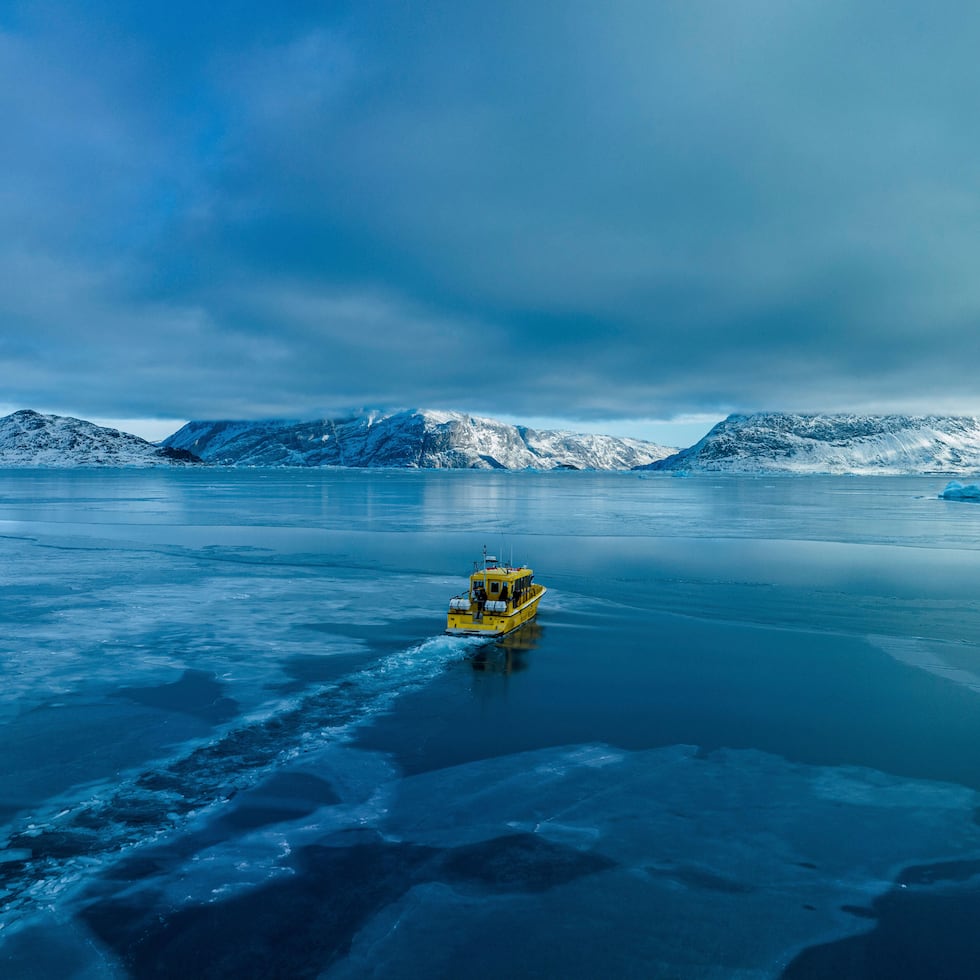 Un barco navega por una bahía con agua congelada a las afueras de Nuuk, Groenlandia.