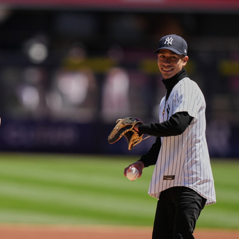 La entrenadora de Golden Tempo, Cherie DeVaux (izquierda), y José Ortiz realizan el primer lanzamiento ceremonial antes del partido de béisbol entre los Yankees de Nueva York y los Rangers de Texas.