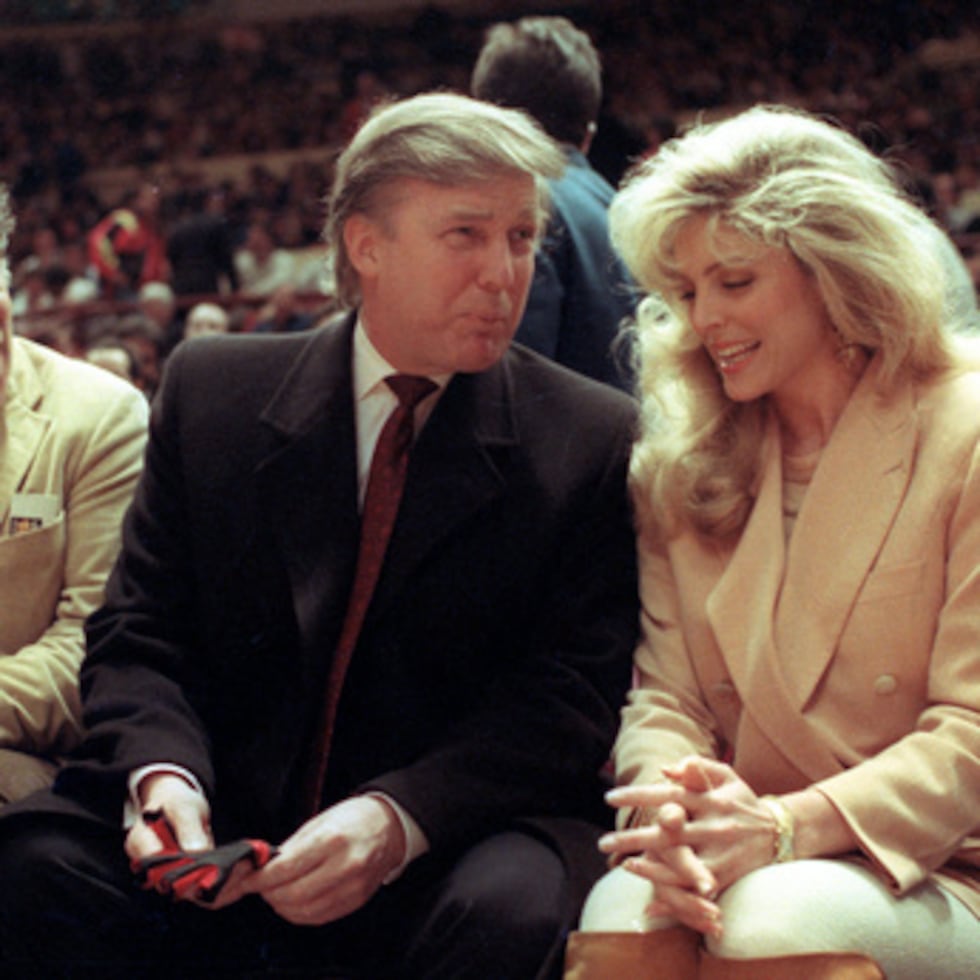 El actor Elliott Gould, a la izquierda, se une a Donald Trump, en el centro, y Marla Maples en la cancha durante un partido de baloncesto de la NBA entre los Phoenix Suns y los New York Knicks en el Madison Square Garden, en Nueva York, el 6 de marzo de 1991.