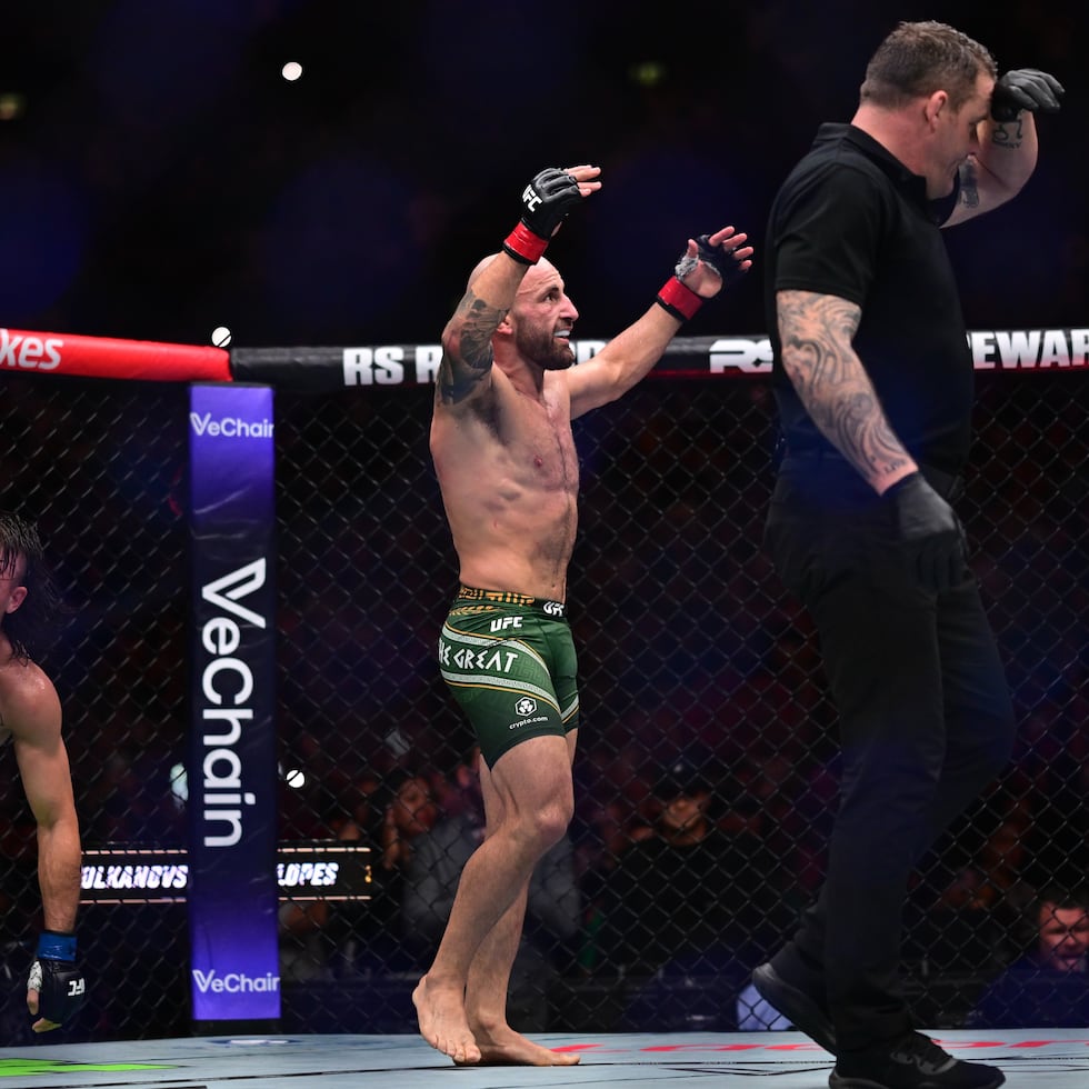 El australiano Alexander Volkanovski, al centro, en su combate por el título peso pluma contra el brasileño Diego Lopes.