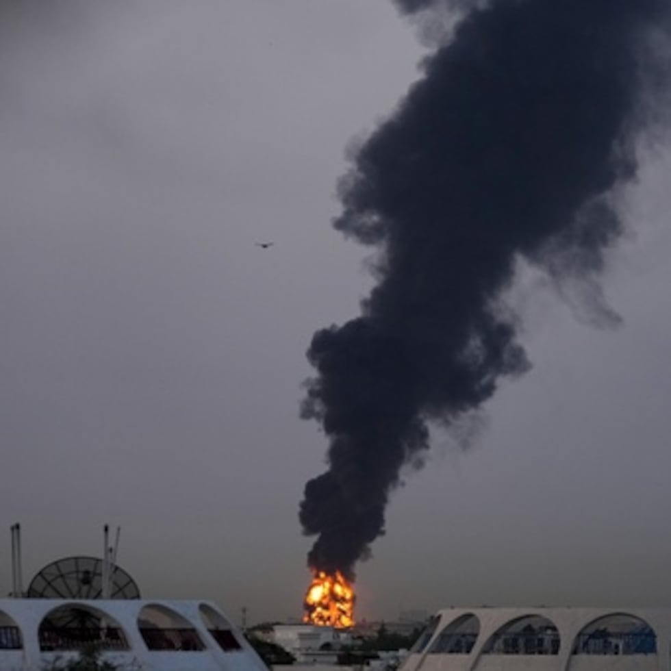 El fuego y las columnas de humo se elevan después de que un avión no tripulado golpeara un tanque de combustible obligando a la suspensión temporal de los vuelos cerca del Aeropuerto Internacional de Dubái.