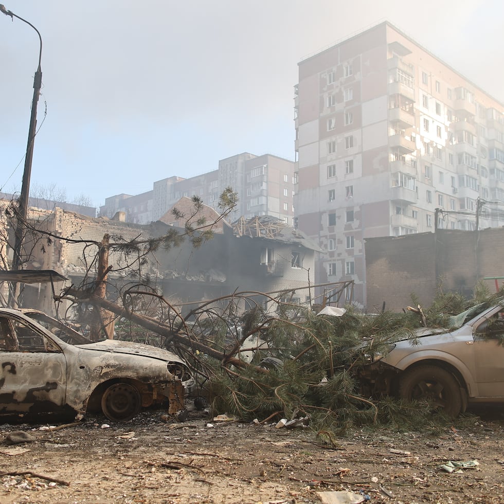 Automóviles calcinados frente a un edificio residencial que resultó gravemente dañado en un ataque ruso.