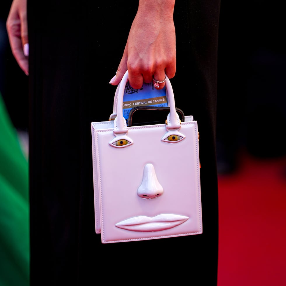 Una mujer lleva un bolso con la imagen al relieve de un rostro, durante la alfombra roja de "Hope", en la edición 79 del Festival Internacional de Cine de Cannes, en Francia.