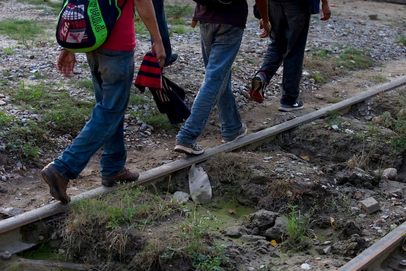 Un grupo reducido de migrantes hondureños que intenta llegar a la frontera de Estados Unidos camina por una vía del tren en Trancas Viejas, estado de Veracruz. (AP Foto/Rebecca Blackwell)