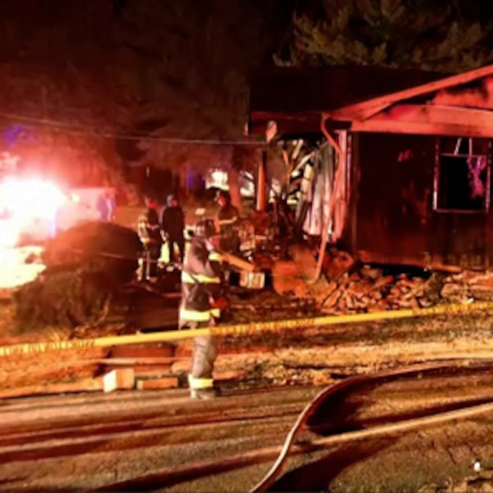 Los bomberos miran por encima de la escena de una explosión de incendio de una casa a finales del lunes, 15 de diciembre 2025 en Salisbury, Carolina del Norte.