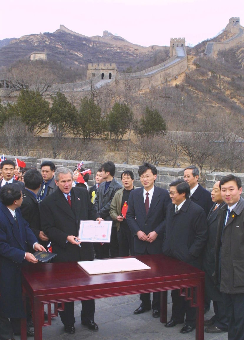El presidente estadounidense George W. Bush muestra un certificado que le fue entregado tras escalar la Gran Muralla en Badaling, en las afueras de Pekín, el 22 de febrero de 2002.