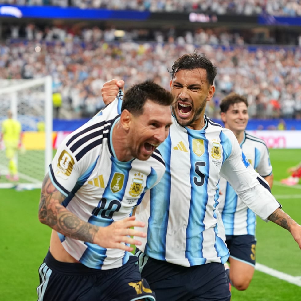 Leandro Paredes (5) agarra de la camiseta a su compañero Lionel Messi al celebrar el segund gol de Argentina en la victoria 2-0 ante Austria en el Grupo J del Mundial.