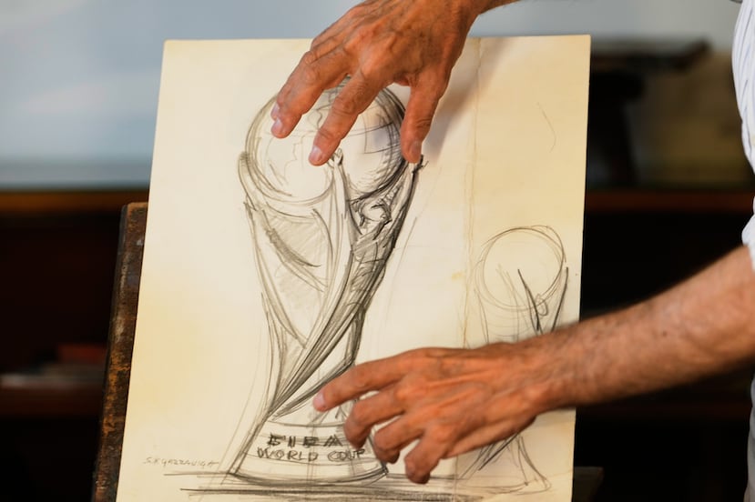 Giorgio Gazzaniga, hijo del fallecido escultor Silvio Gazzaniga, gesticula mientras explica a The Associated Press el dibujo original del trofeo.