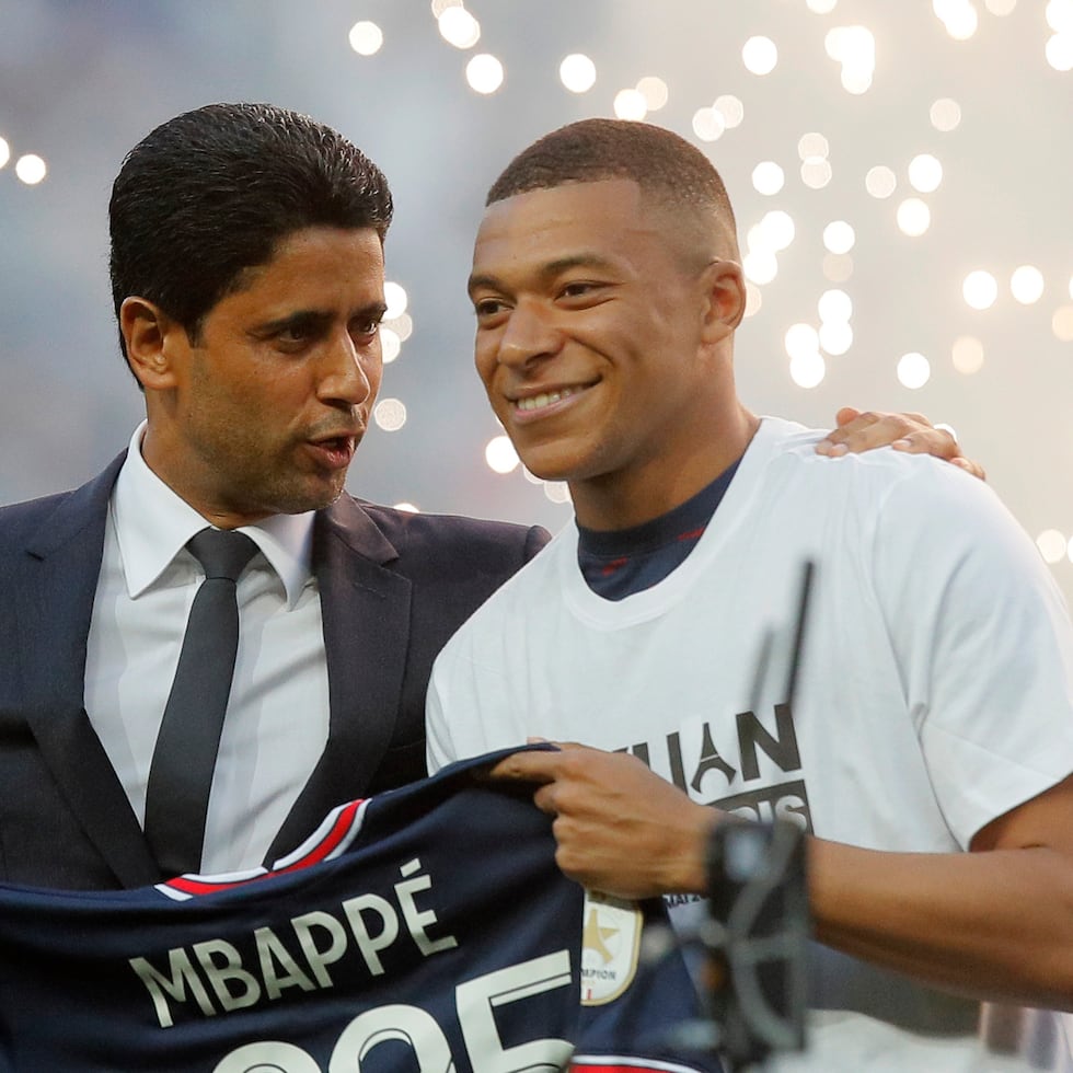 El presidente del Paris Saint-Germain Nasser Al-Khelaifi (izquierda) charla con Kylian Mbappé al ser presentado en el estadio Parque de los Príncipes, el 21 de mayo de 2022, en París.