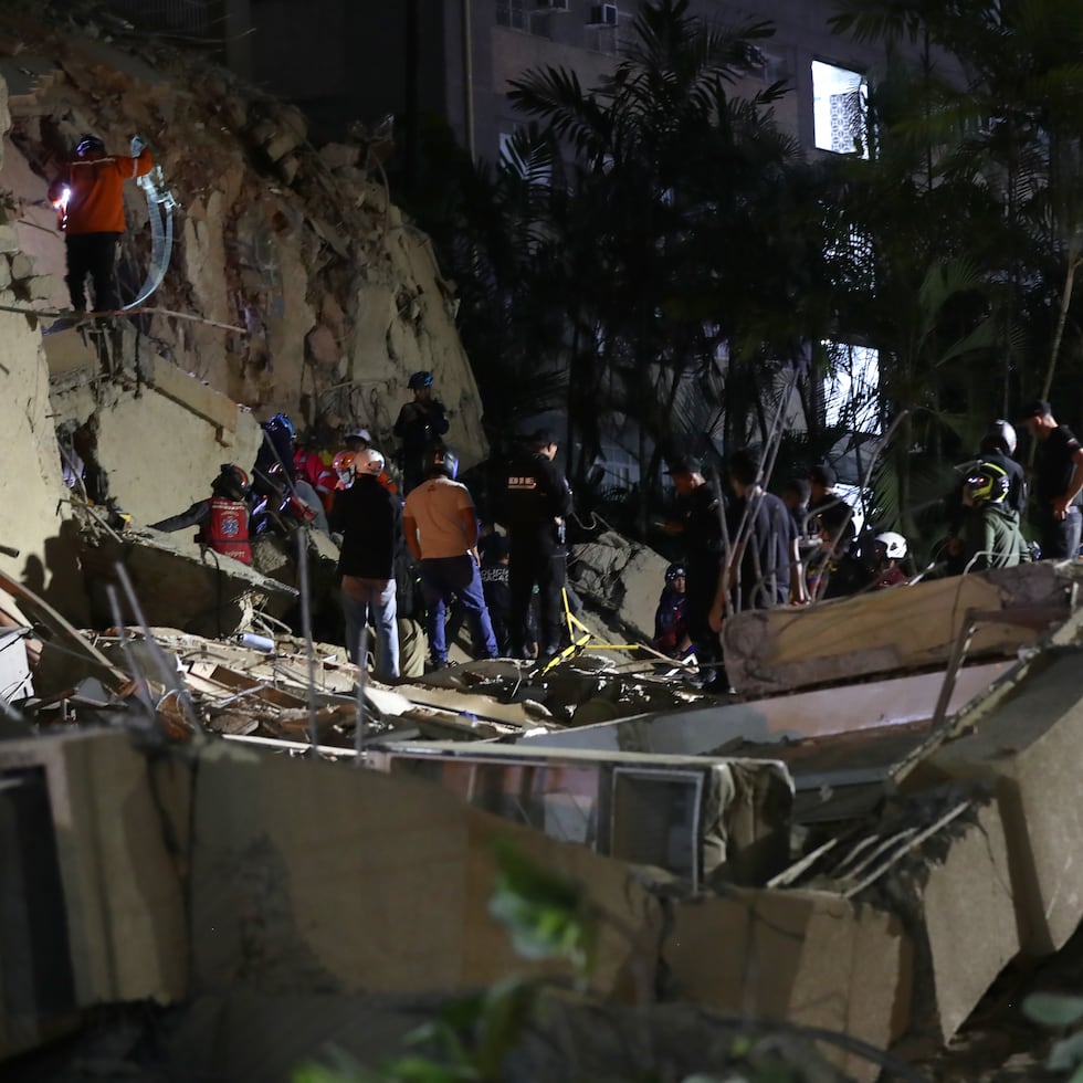 Integrantes de cuerpos de emergencia buscan víctimas.