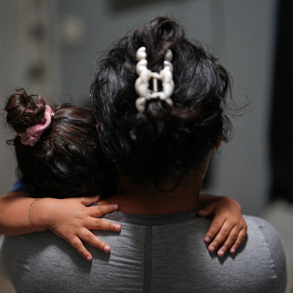 Yaoska, de 32 años, embarazada y solicitante de asilo, consuela a su hijo de dos años que no se encontraba bien, dentro de la habitación de motel del área de Miami donde ella y sus hijos viven después de que su marido fuera deportado a Nicaragua.