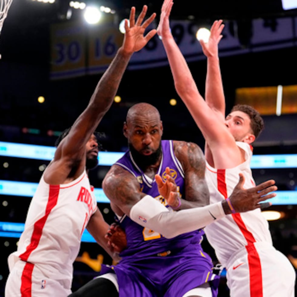 El alero de los Lakers de Los Ángeles LeBron James, centro, pasa el balón mientras el alero de los Rockets Tari Eason, izquierda, y el pívot Alperen Sengun defienden durante la primera mitad del quinto partido de la serie, la cual se trasladará a Houston.