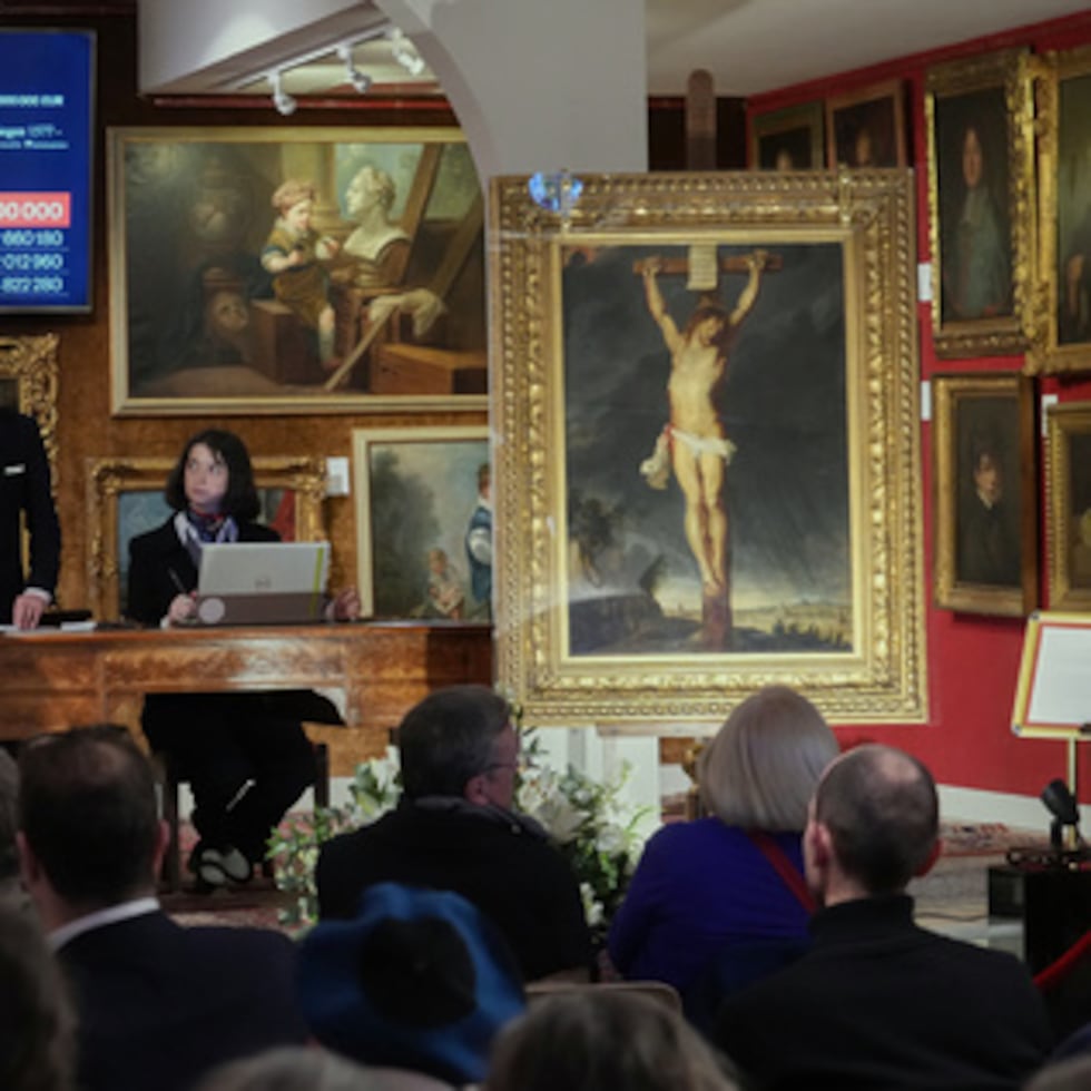 El subastador Jean-Pierre Osenat gesticula mientras el cuadro "Crucifixión de Jesucristo", del maestro barroco Peter Paul Rubens, vendido en subasta por 2,3 millones de euros o 2,66 millones de dólares en Versalles, al oeste de París, el 30 de noviembre de 2025. (AP Photo/Michel Euler)