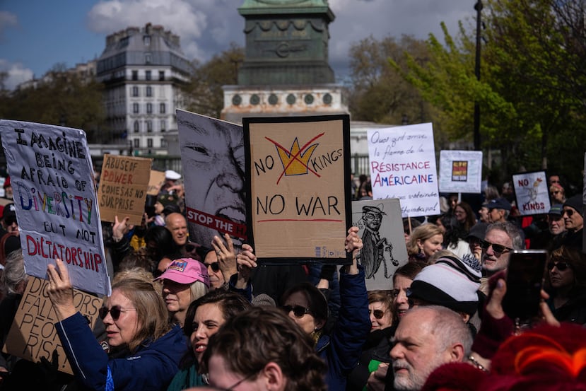 Una mujer que sostiene una pancarta con el lema "No a los reyes, no a la guerra" participa en la protesta "No a los reyes" en París, Francia, el sábado 28 de marzo de 2026. (Foto AP/Aurelien Morissard)
