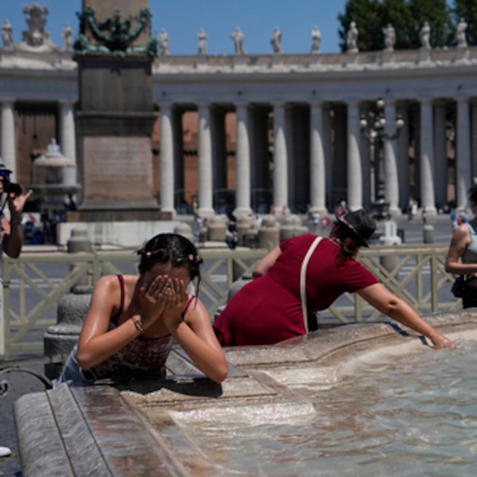 La gente se refresca en una fuente tras la oración del Ángelus del mediodía, celebrada por el papa León XIV desde la ventana de su estudio con vistas a la plaza de San Pedro, en el Vaticano.