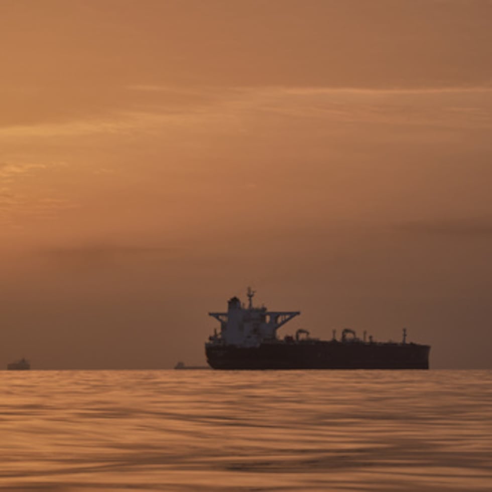 El sol sale tras varios petroleros fondeados en el estrecho de Ormuz en la costa de la isla de Queshm, Irán.