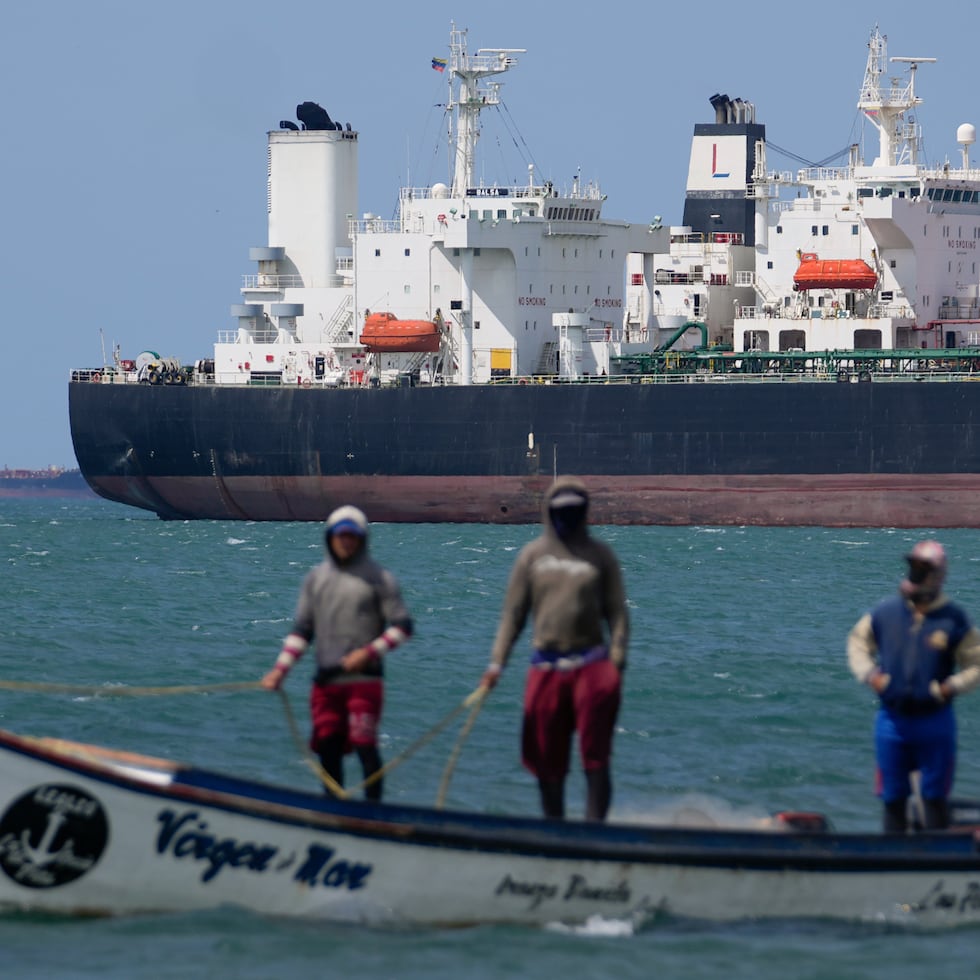 Pescadores pasan junto a un petrolero en el Golfo de Venezuela, frente a la costa de Punta Cardón, Venezuela.