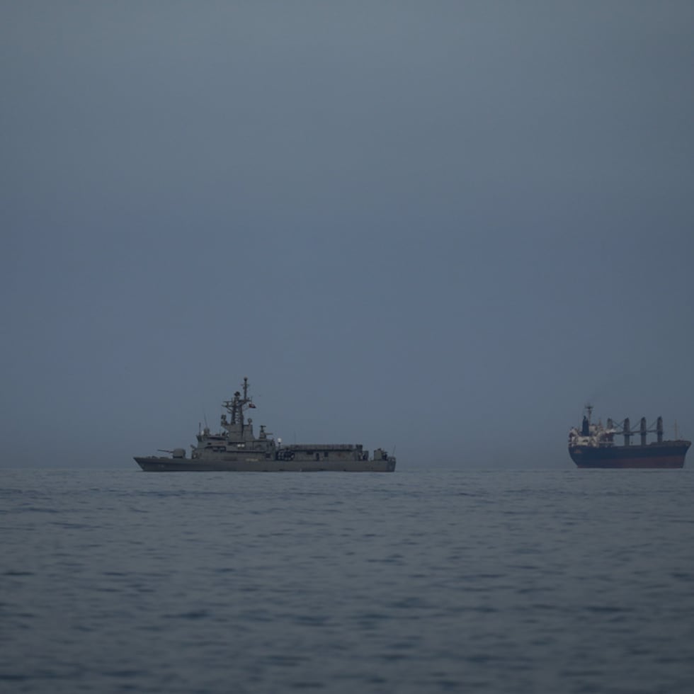 Un buque de la marina de Emiratos Árabes Unidos patrulla junto a barcos de carga y petroleros en el Estrecho de Ormuz.