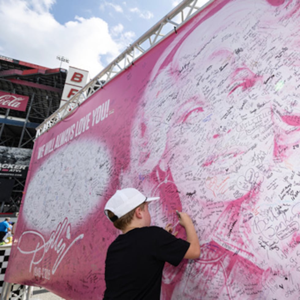 Henry Bailey, de 7 años, de Kentucky, firma un cartel en homenaje a la fallecida Dolly Parton antes de una carrera de la NASCAR Cup Series el sábado 19 de septiembre de 2026, en Bristol, Tennessee. (Foto AP/Wade Payne)