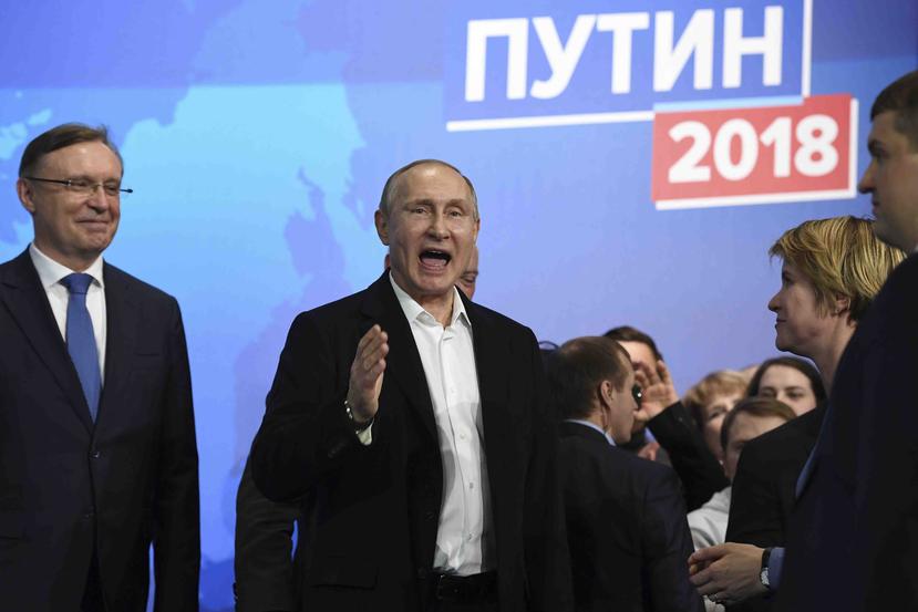 El presidente ruso Vladimir Putin, al centro, también candidato presidencial, habla en su sede de campaña en Moscú, Rusia. (AP)
