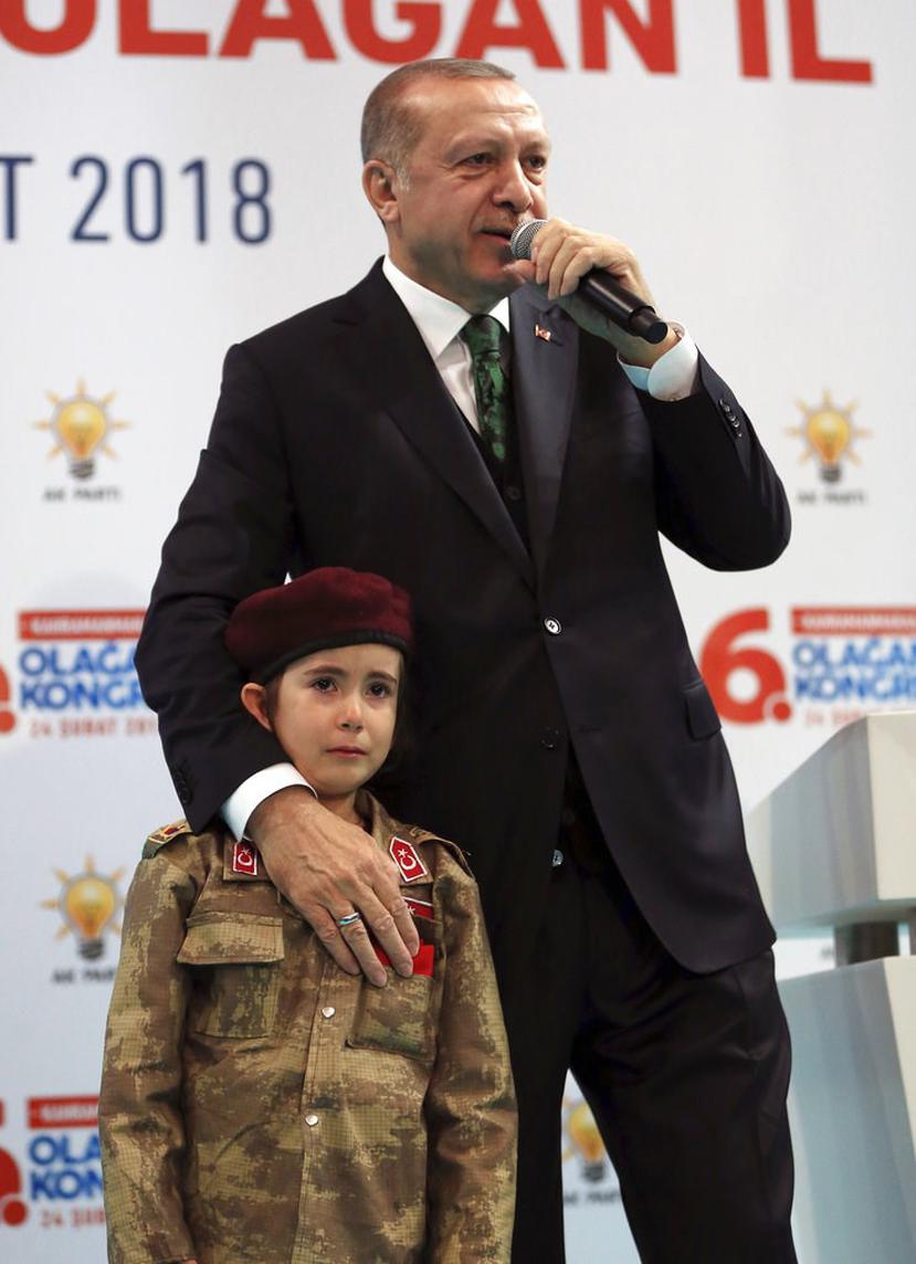 El presidente de Turquía, Recep Tayyip Erdogan, de pie junto a una niña con uniforme militar durante un discurso a miembros de su partido gobernante, en Kahramanmaras, Turquía (Murat Cetinmuhurdar/Pool Foto vía AP).