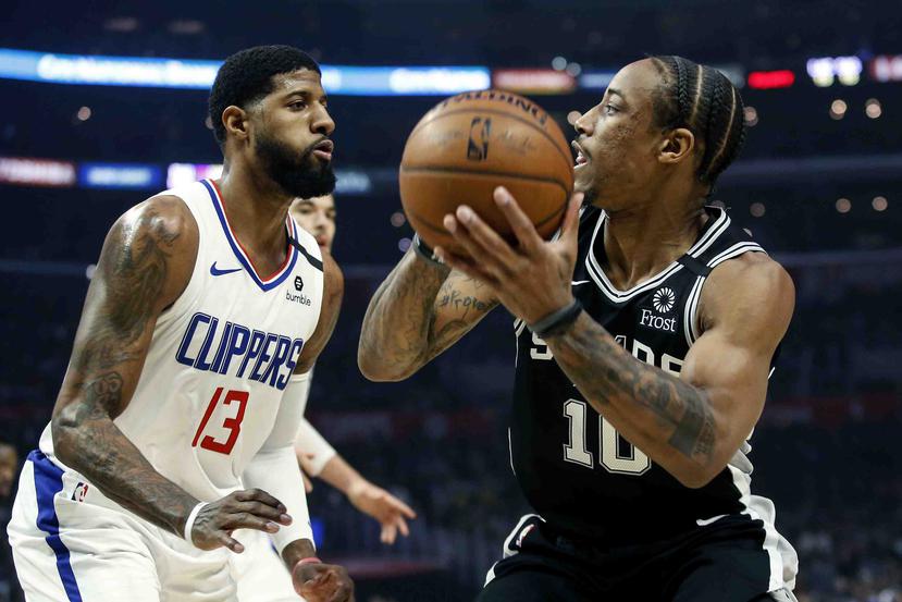 El jugador de los Spurs de San Antonio DeMar DeRozan (10) intenta pasar el balón ante la presión de su rival de los Clippers de Los Ángeles Paul George (13). (AP)