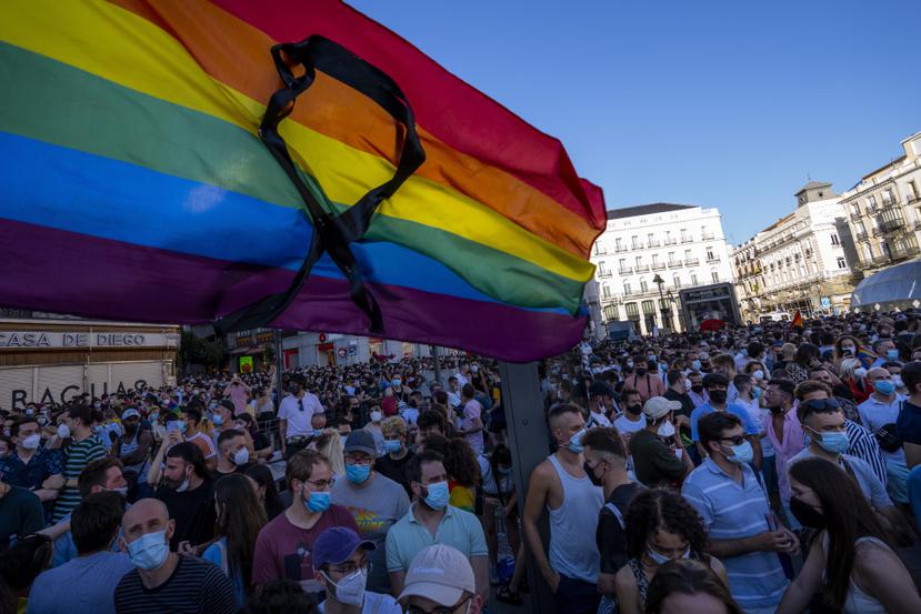 La bandera arcoíris con un listón negro ondea durante una protesta en contra del asesinato de Samuel Luiz, en la Puerta del Sol, el lunes 5 de julio de 2021, en Madrid. (AP Foto/Bernat Armangue)