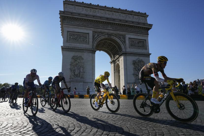Jonas Vingegaard (de amarillo) pasa frente al Arco del Triunfo durante la 21ra etapa del Tour de Francia.