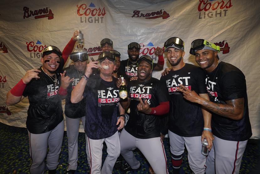 Eddie Rosario (segundo de derecha a izquierda) y varios integrantes de los Braves posan en medio de la celebración del equipo.