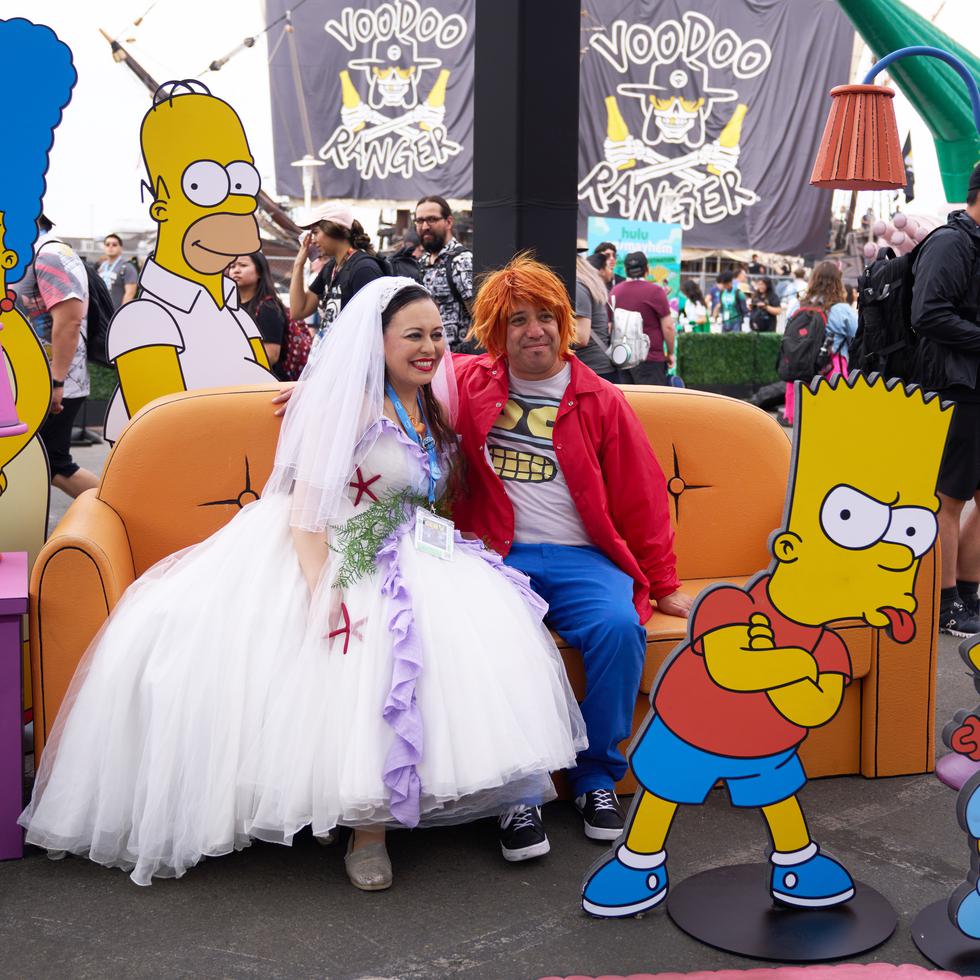 Dos personas posan frente a los personajes del programa "The Simpsons" a las afueras del Comic-Con 2023, celebrado en San Diego, California.