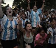 Fanáticos de la selección de Argentina celebran que su equipo haya superado a Holanda 4-3 en la tanda de penaltis en los cuartos de final de la Copa del Mundo, en Catar.
