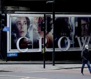 Un hombre pasa frente a un anuncio de la serie de Netflix "The Crown" en Londres.