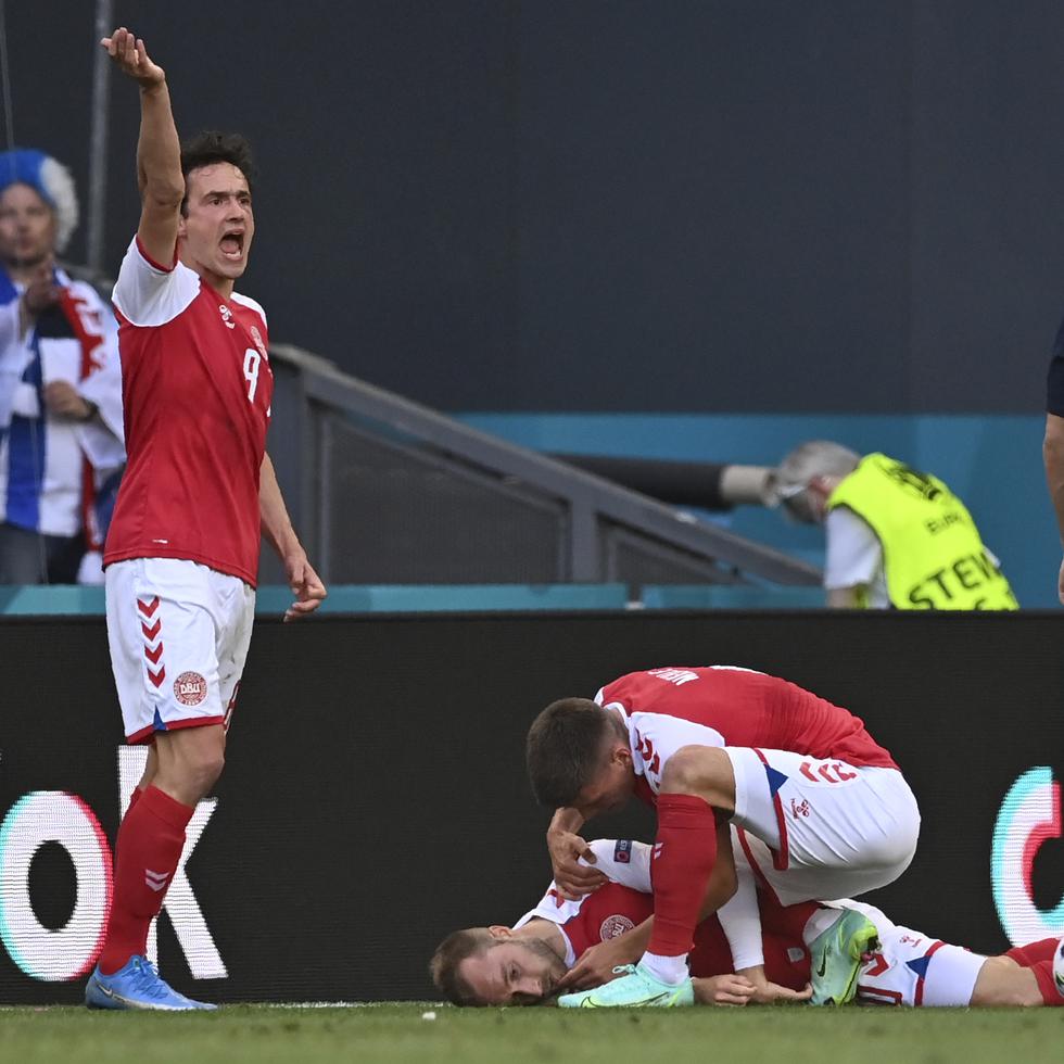 Jugadores de la selección de Dinamarca tratan de socorrer a su compañero Christian Eriksen, quien se desvaneció durante un partido de la Eurocopa ante Finlandia, el sábado 12 de junio en Copenhague.