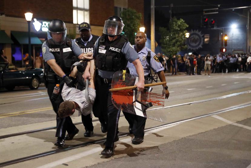 La policía arrestó ayer a un hombre mientras intentan dispersar una protesta violenta, el 16 de septiembre de 2017, en University City, Missouri. (AP)