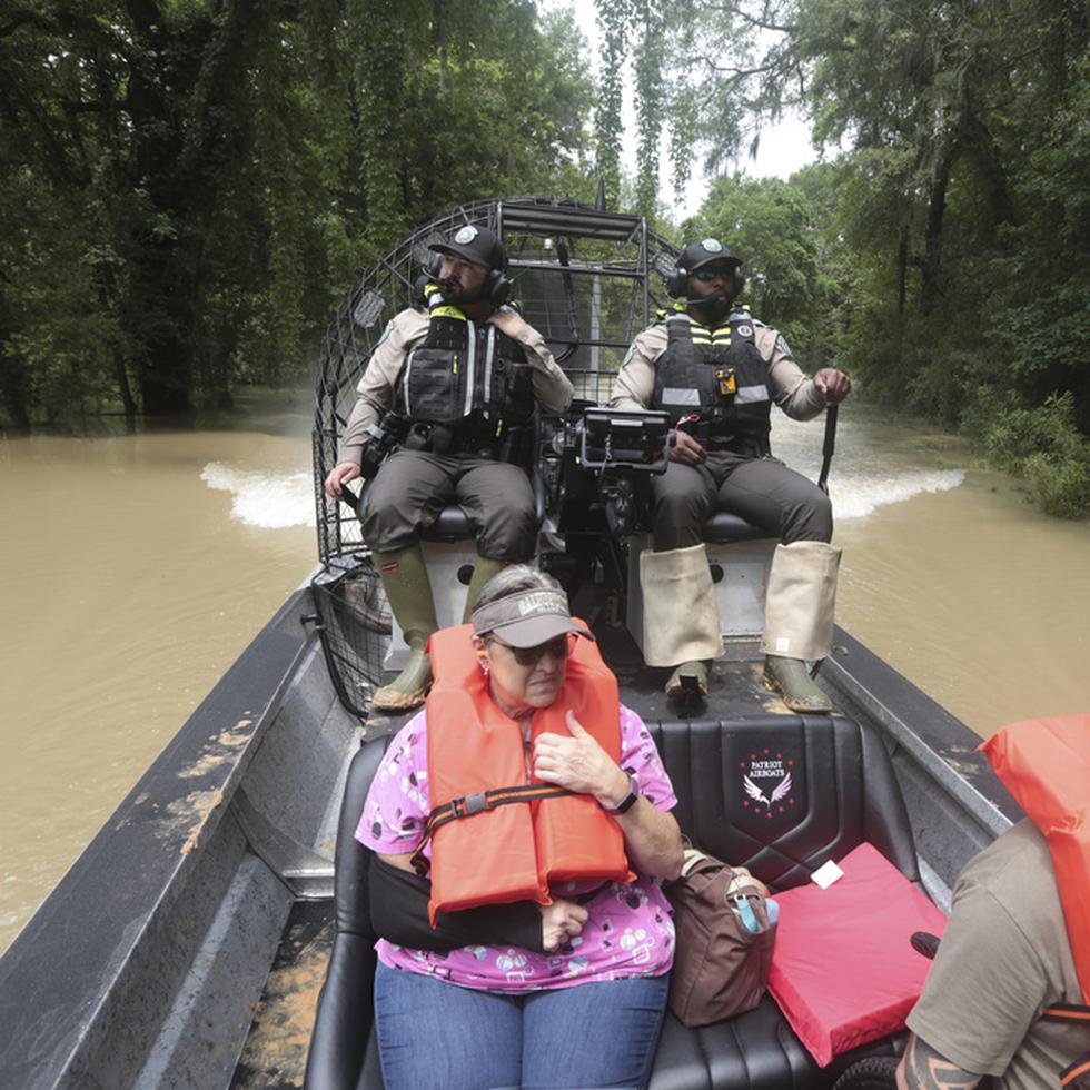 Guardias del Departamento de Parques y Vida Silvestre de Texas, utilizan un bote para rescatar a residentes de las inundaciones en el condado Liberty, Texas.