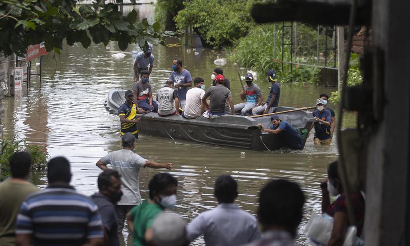 Los habitantes de Sri Lanka varados debido a las inundaciones viajan en un bote en una calle inundada tras las fuertes lluvias en Malwana, en las afueras de Colombo, Sri Lanka.