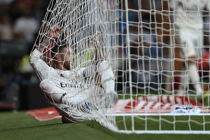 Sergio Ramos, del Real Madrid, parece acostarse en la malla de la portería durante un partido. (AP)