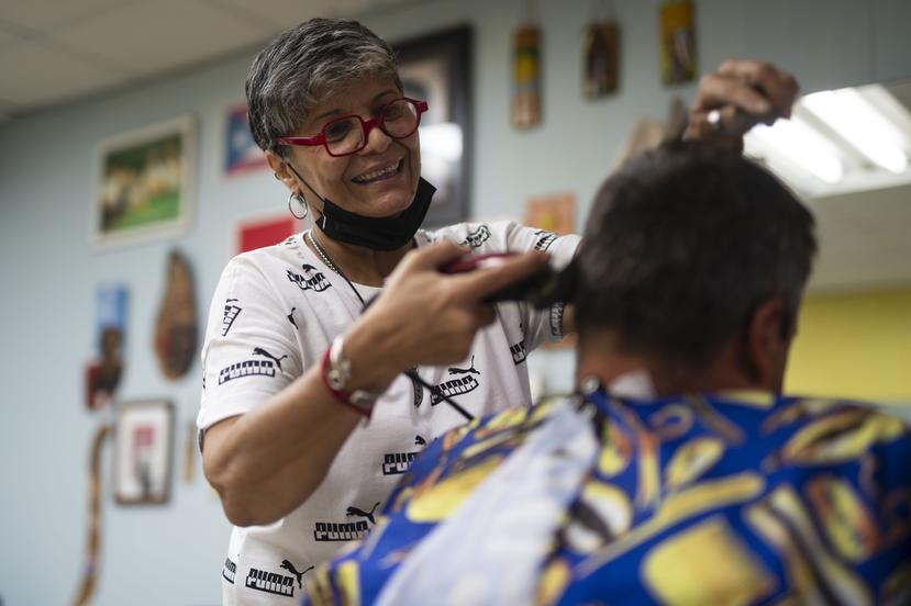 Utuado, P.R. - Letty Martínez Afanador with a client at her barbershop.