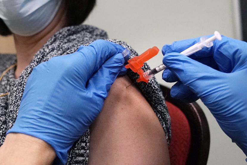 Una mujer recibe una dosis de la vacuna contra COVID-19 por parte de un farmacéutico en una clínica de Lawrence, Massachusetts.