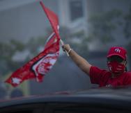 Un seguidor del PPD ondea la bandera del partido frente a su sede.