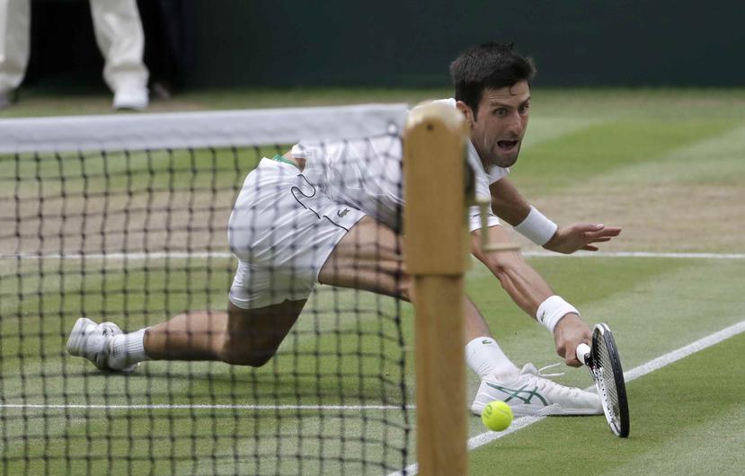 El serbio Novak Djokovic le devuelve la bola al español Rafael Nadal dueante la semifinal masculina del prestigioso campeonato de tenis Wimbledon.  (AP)