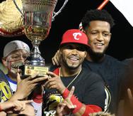 Jugadores de los Criollos cargan con el trofeo de campeonato de béisbol invernal tras derrotar a los Indios.