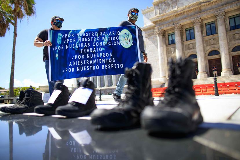 Los manifestantes colocaron frente al Capitolio botas que usan en su labor como oficiales correccionales reclamando que legisladores y jefes en el gobierno se pongan "en su posición" para que entiendan sus reclamos.