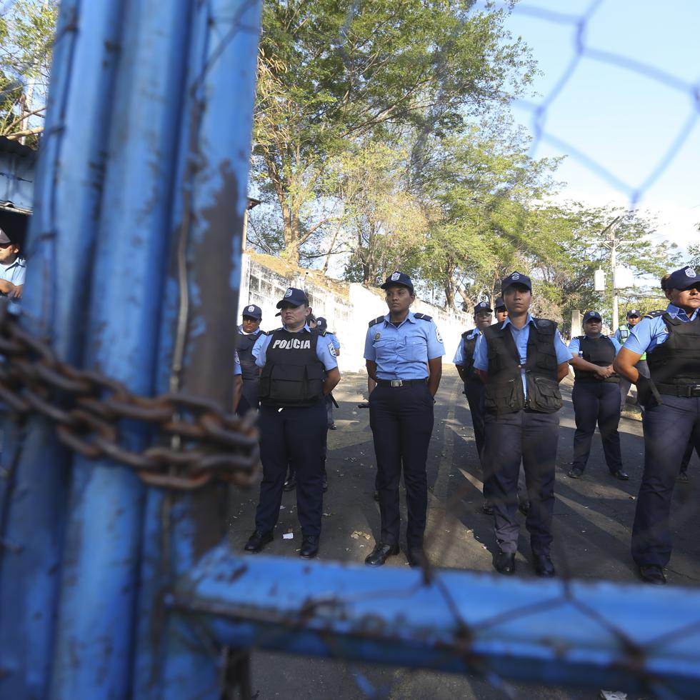 Policías montan guardia en un centro de detención conocido como "El Chipote", asociado a la tortura durante la dictadura de Somoza (1937-1979) y oficialmente llamado Dirección de Auxilio Judicial, mientras se enfrentan a manifestantes, del otro lado del cerco, que protestan los arrestos de manifestantes antigubernamentales en Managua, Nicaragua, 25 de abril de 2018.