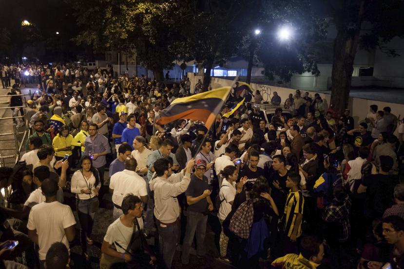 Un grupo de personas celebra la victoria obtenida por la coalición opositora Mesa de Unidad Democrática (MUD), hoy en Caracas. (EFE)