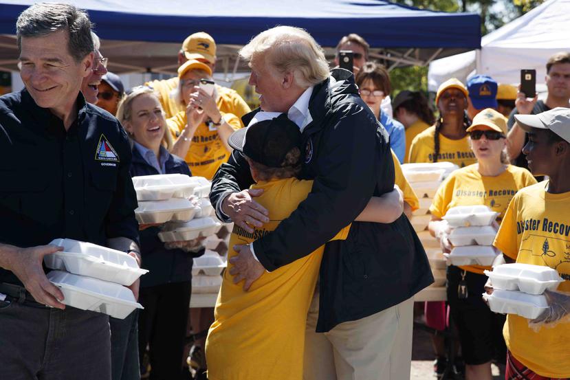 Donald Trump abraza a un niño durante una entrega de comidas en una iglesia bautista en New Bern, Carolina del Norte. (AP)