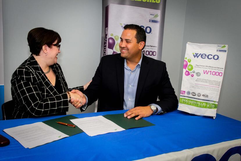 Desde la izquierda: Mary Ann Gabino, vicepresidenta de FCPR, y Jorge Muñoz, gerente general de Weco, firman el acuerdo para crear el Fondo Comunitario Weco.